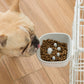 White plastic anti-choke hanging pet bowl with kibble, attached to cage side