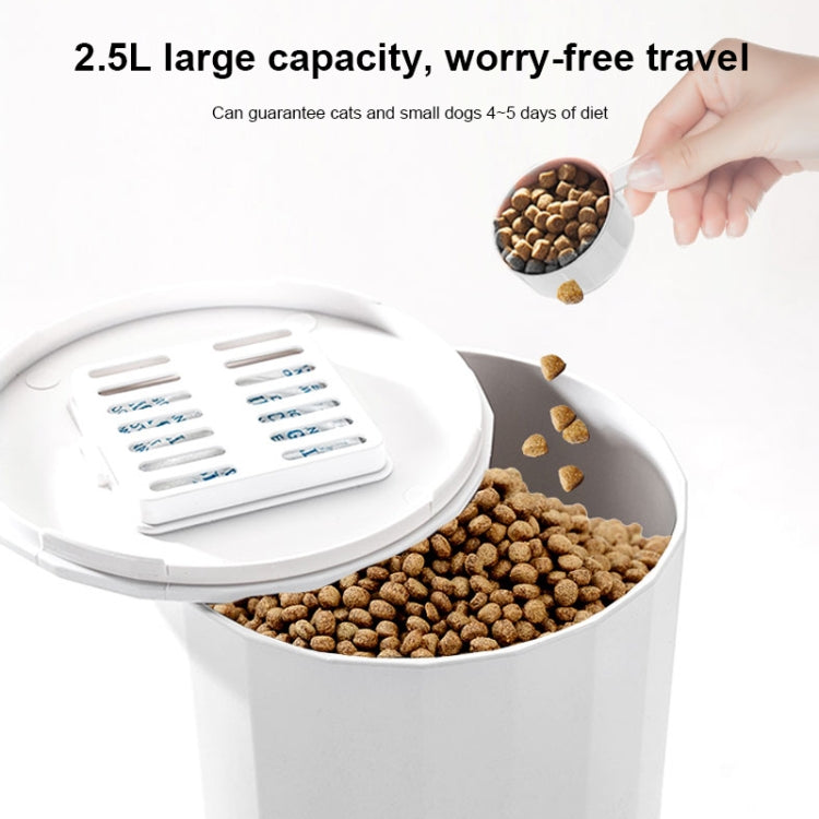 White automatic pet feeder with open top tray and kibble being poured from hand