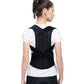 Black posture correction back brace with mesh shoulders and lumbar band, worn over white shirt