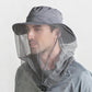 Adult wearing wide-brim anti-mosquito hat with mesh face net and chin strap, gray