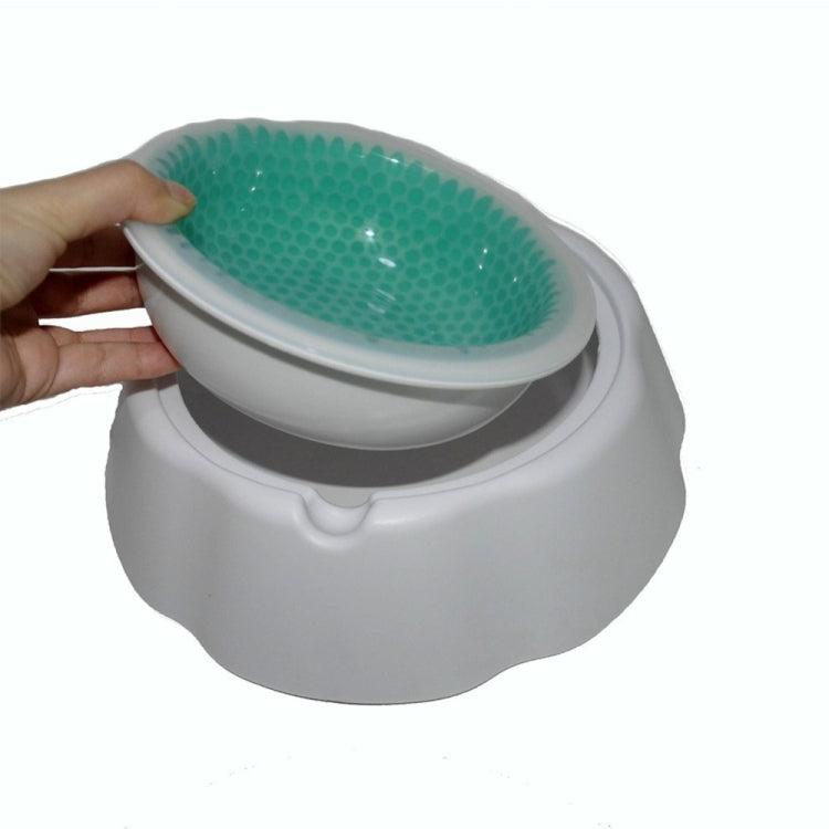 Hand holding a white pet cooling bowl lid, revealing the green textured insert