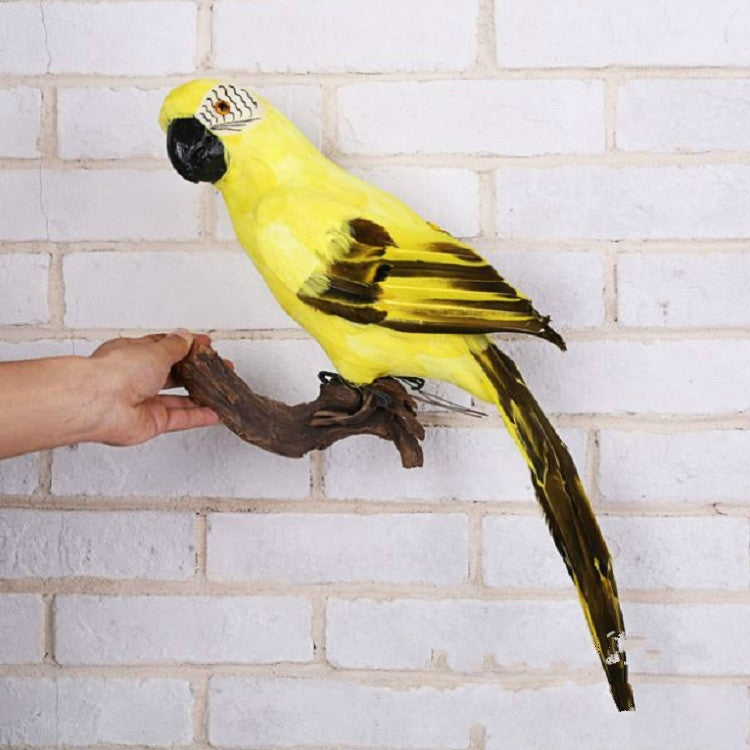 Yellow foam parrot decoration with black wing tips, perched on a branch