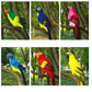 Colorful simulated parrot bird decorations in green, blue, and pink on tree branches