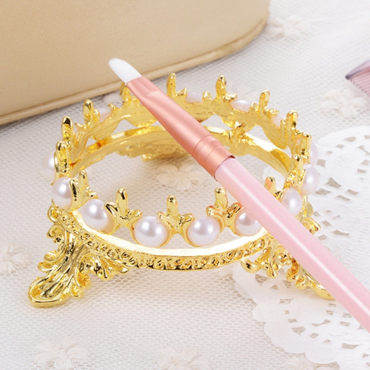 Gold-tone crown holder with white pearl beads, holding a pink nail art brush pen