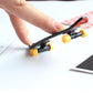 Mini finger skateboard with yellow wheels, finger pushing the black and red deck