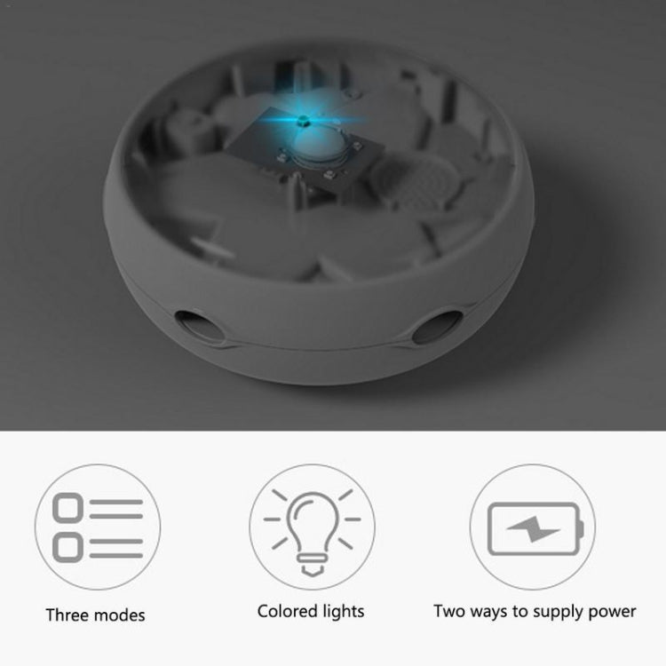 Underside of white rotating cat toy with blue LED glow and mode icons