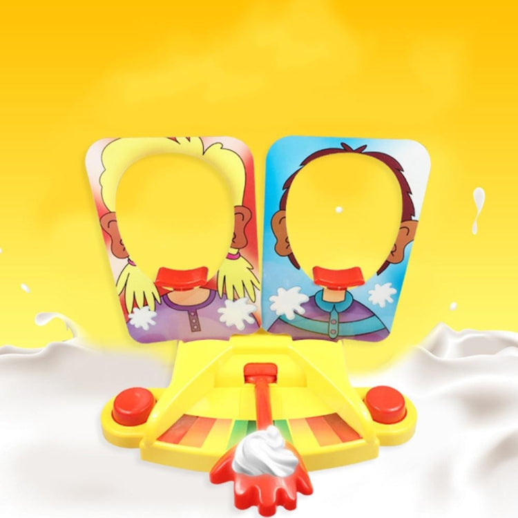 Pie face prank game toy with two face panels and yellow board with red lever and whipped topping