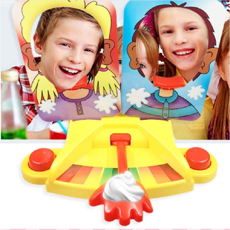 Pie face prank game toy with two character face panels, yellow base, and red lever with topping
