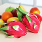 Red dragon fruit ornament set with green leaves, arranged in a group for display