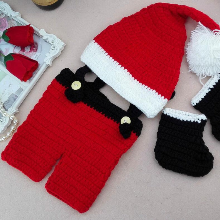 Hand-knit baby set: red pom-pom hat, red romper with black straps, and black socks