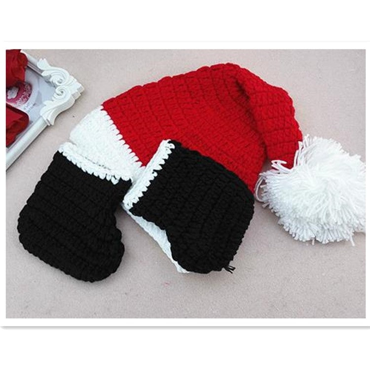 Knit baby romper with red top and white trim, black shorts, and black booties