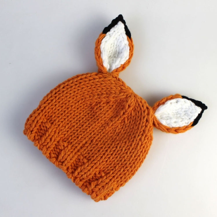 Orange knit fox hat and matching pants set, flat lay with ear and face patches