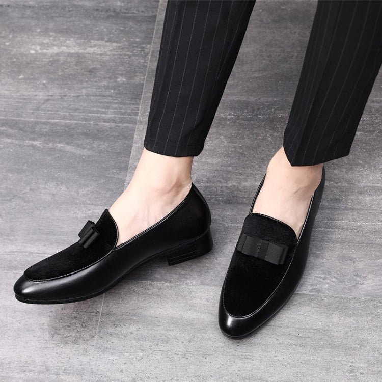 Men's black loafers with bowknot strap on feet, low heel and rounded toe