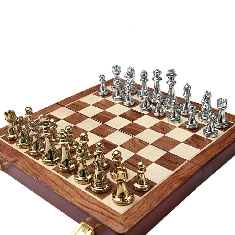 Chess set board with gold and silver metal pieces arranged for play