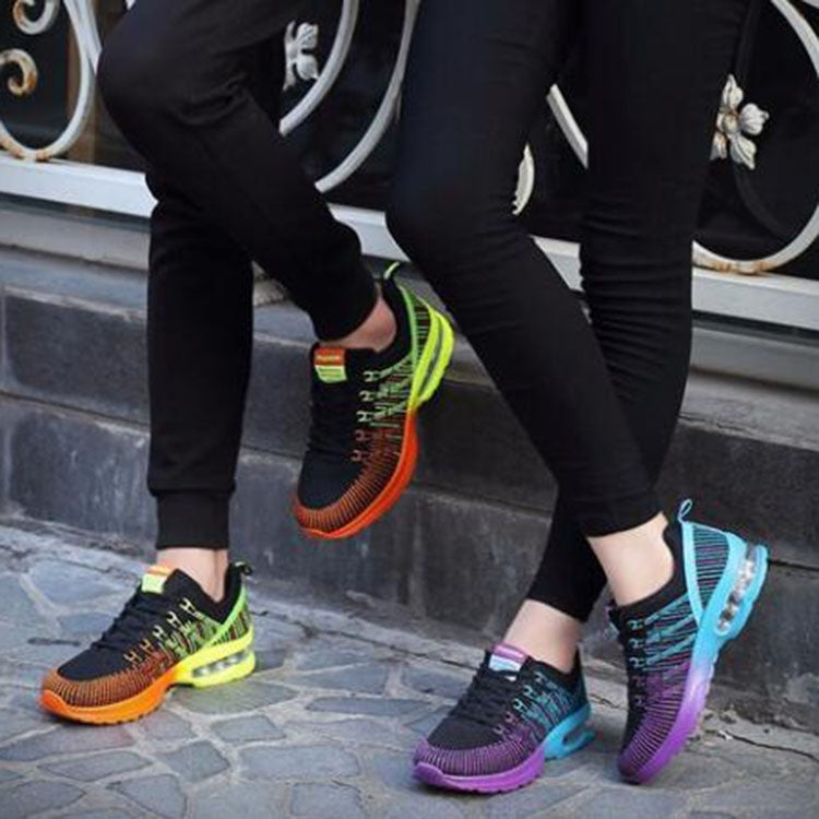 Pair of women’s lace-up mesh sneakers on pavement in black and purple with air sole