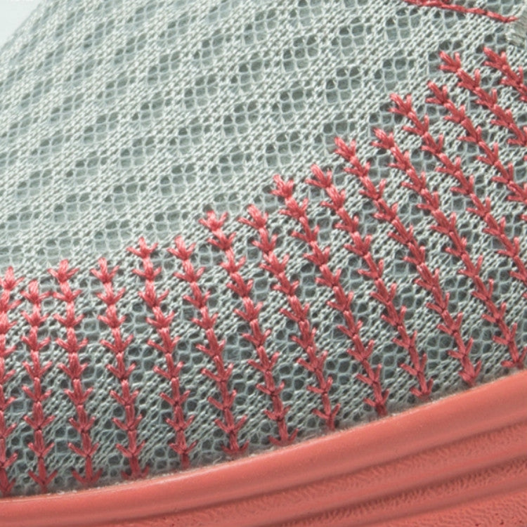 Close-up of knitted mesh upper with red pattern and coral rubber edge