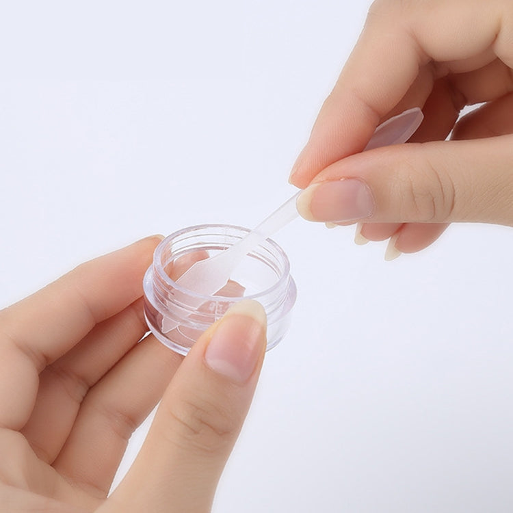 Hands holding a small clear screw-top empty bottle with a white cap insert