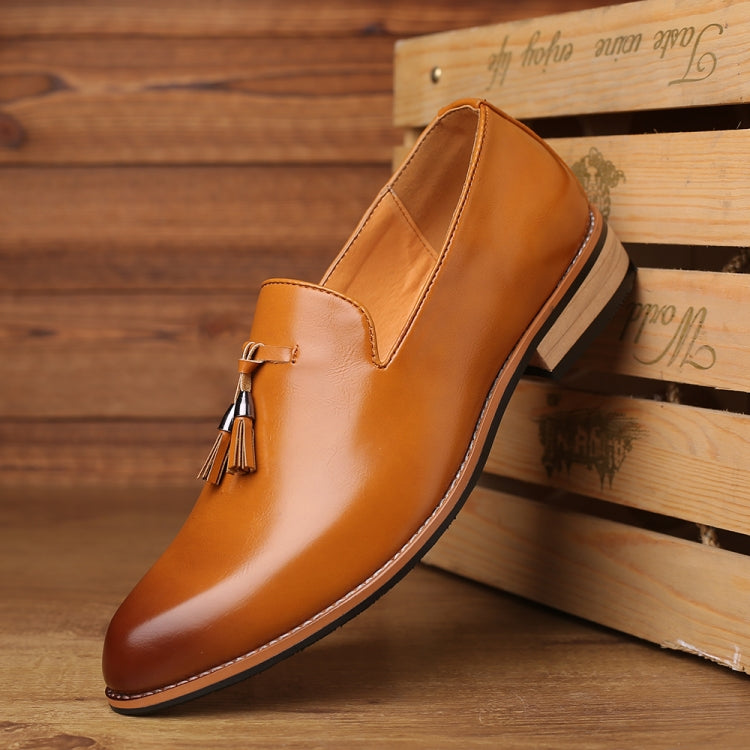 Men's tan pointed dress shoe, side view with tassel accent and low rubber sole