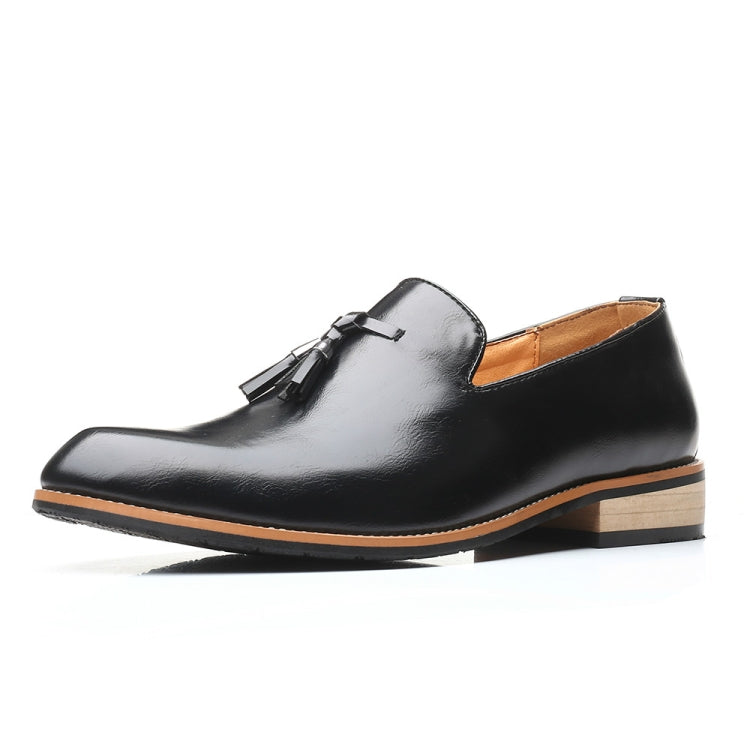 Black pointed loafer dress shoe with tassel ornament and soft rubber sole, front-side view