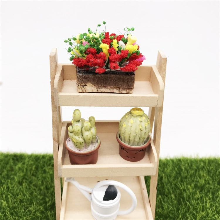 Mini clay flower planter on top shelf of dollhouse garden stand, with small potted cacti
