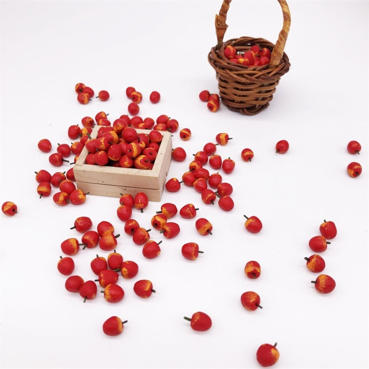 Miniature red apples spilled from small wooden crates and a woven basket.