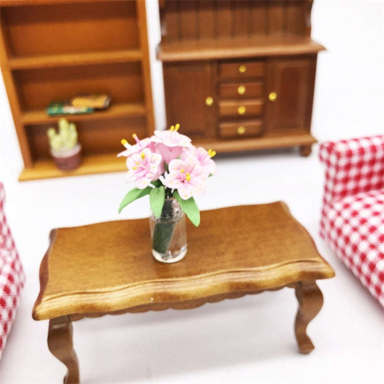 Mini dollhouse lily bouquet in clear glass vase on wooden tabletop
