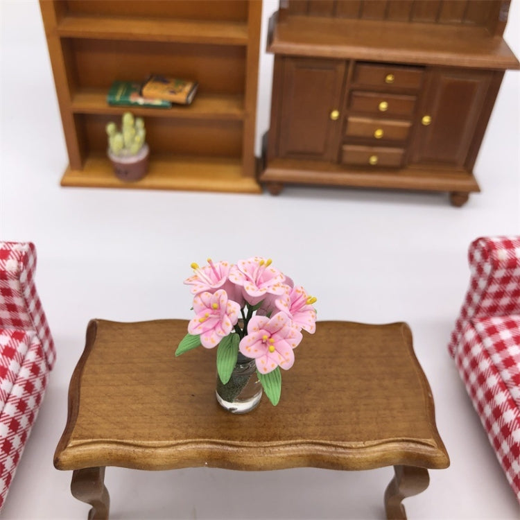 Mini dollhouse lily bouquet in clear glass vase on brown wooden table