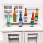 Mini wine drink bottle ornaments set arranged in a dollhouse display shelf, assorted colors.