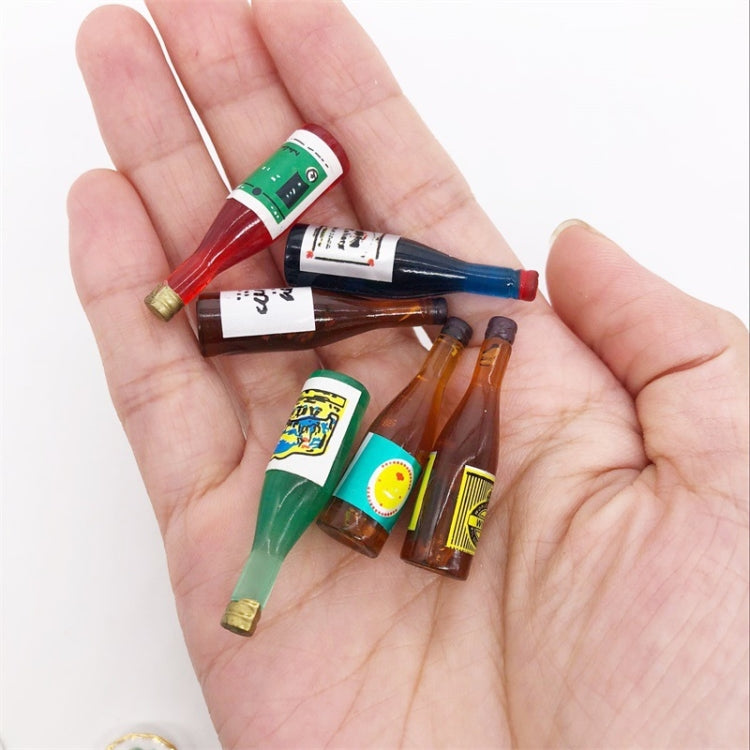 Mini wine drink bottle ornaments in a hand, small blue, red, green, amber bottle shapes.