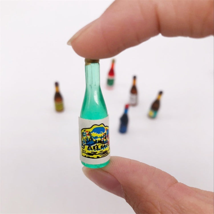 Mini wine drink bottle ornament held between fingers, mint green glass bottle shape.
