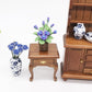Purple rose flower model toy with brown pot centerpiece on miniature wooden table
