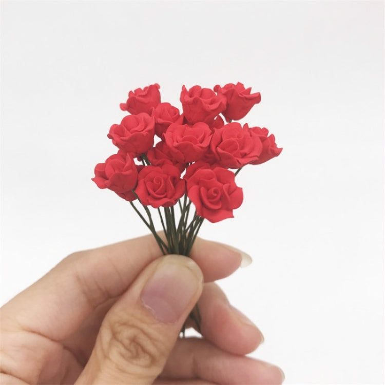 Mini dollhouse rose bunch held in hand, dark red flowers on green stems