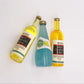 Three mini wine drink bottles with gold caps, yellow and blue drink colors