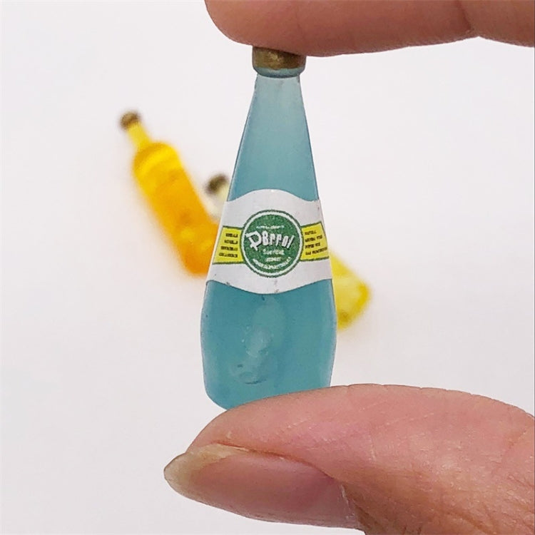 Blue mini wine drink bottle with label, held between fingers