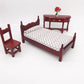 Mini dollhouse single bed toy with dark maroon headboard and white patterned quilted mattress