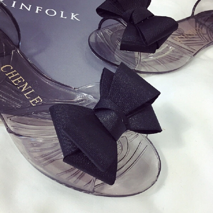 Transparent jelly sandals with large black bow and open toe detail