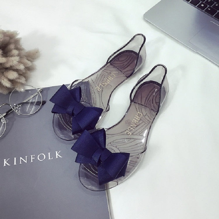 Transparent flat shoes with jellyfish-mouth cutout and three dark bows per shoe