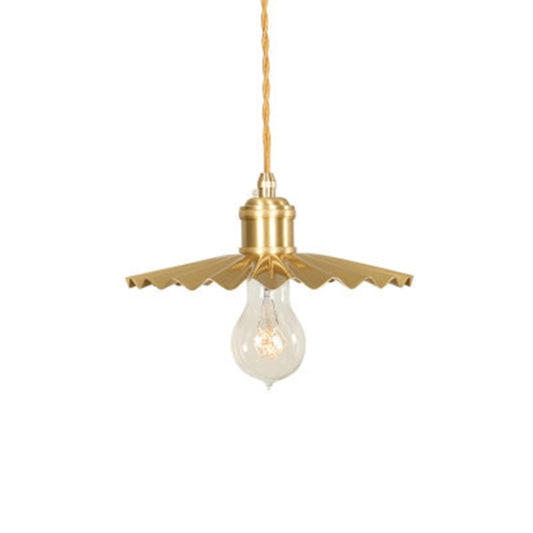 Brass pendant light with pleated canopy and exposed clear bulb on hanging cord