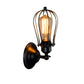 Wall lantern light with black backplate, amber Edison-style bulb in clear glass cage