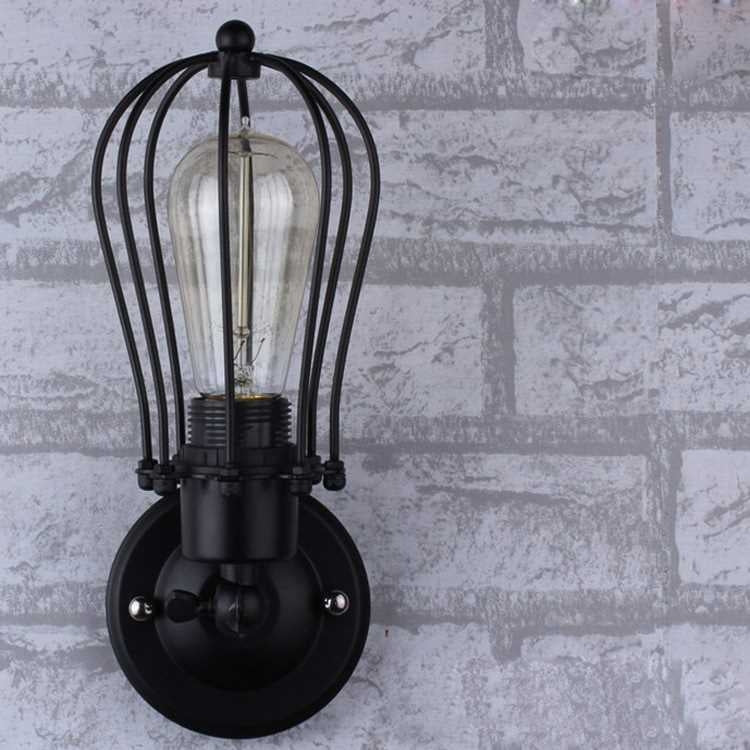 Wall lantern light with matte black cage frame, clear glass tube and lit Edison bulb