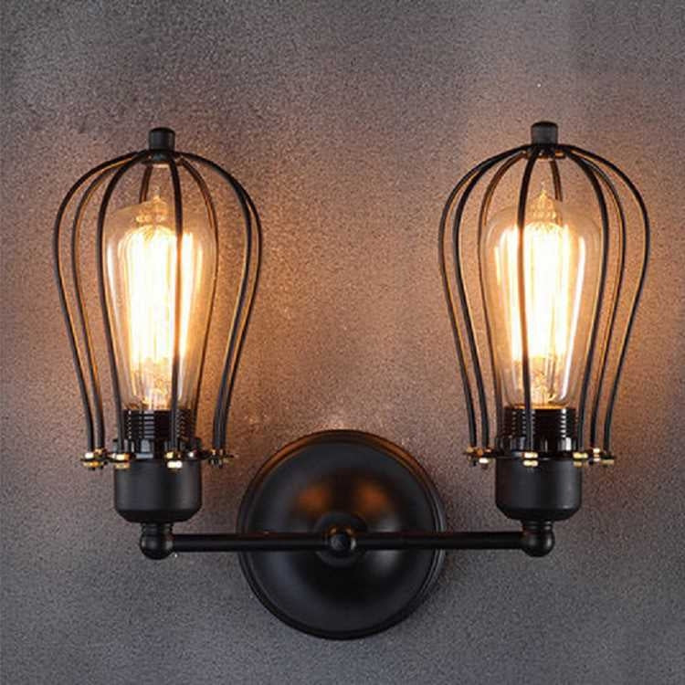 Double-head wall lantern light with black round backplate and two amber Edison bulbs