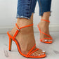 Orange high-heeled sandals with thin toe straps and ankle buckle detail