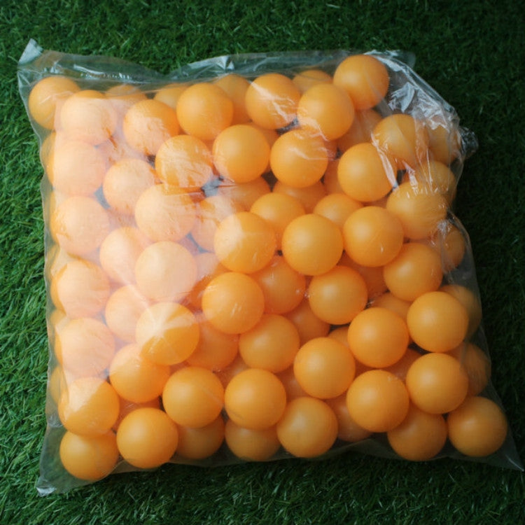 Seamed table tennis balls, orange/yellow, sealed in clear bag on grass