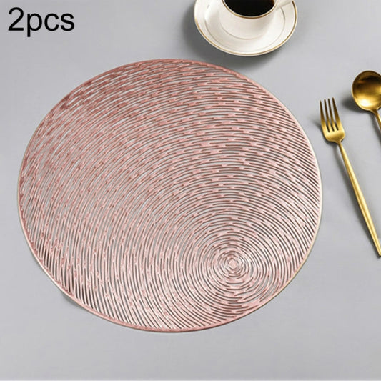 Set of 2 round PVC placemats in rose gold with concentric swirl line pattern