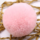Pink faux fur pom-pom ball, close-up