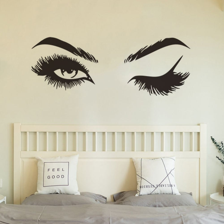 Black eye and eyebrow wall decals above a bed headboard.
