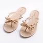 Apricot slip-on flat sandals with rhinestone bow detail across the toe straps