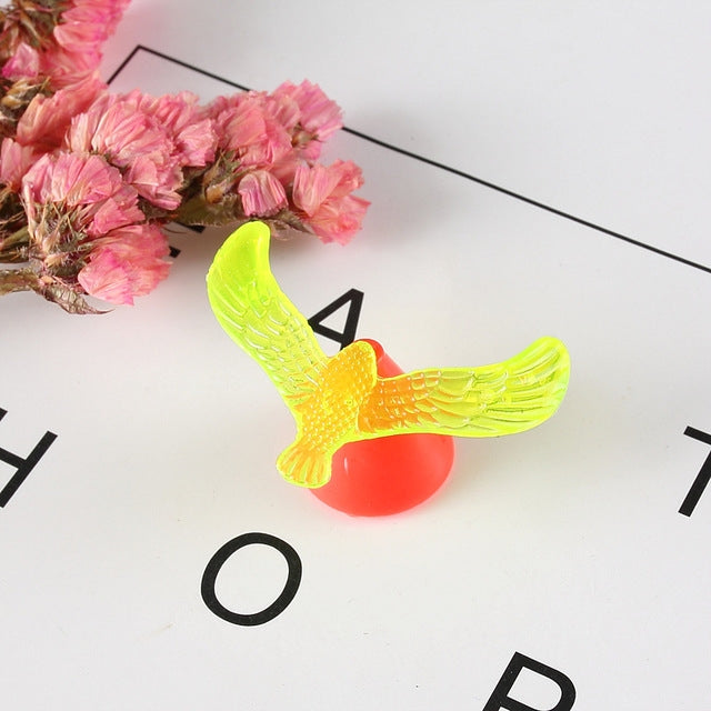 Balancing bird toy with lime green bird and red weighted base