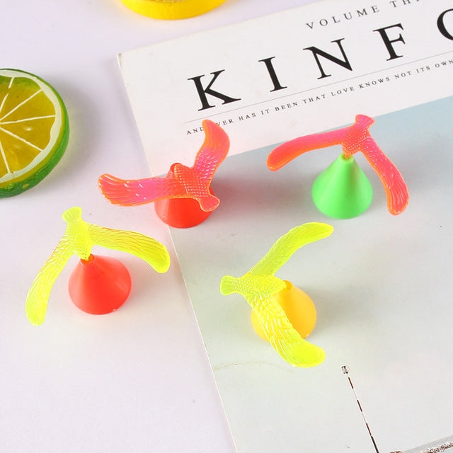 Assorted balancing bird toys: orange, green, red, and yellow plastic birds with bases