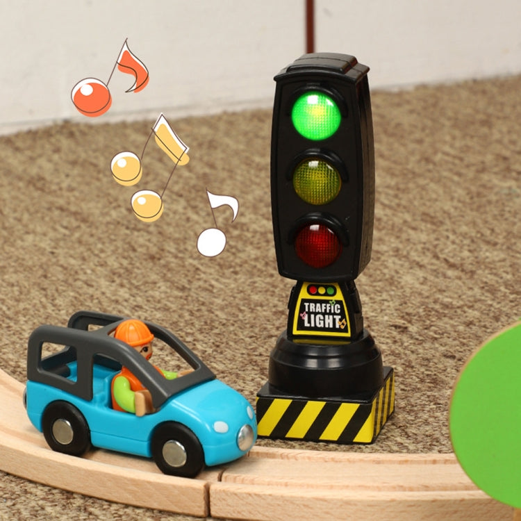 Toy traffic light on base with three lit signal lenses: green, yellow, red